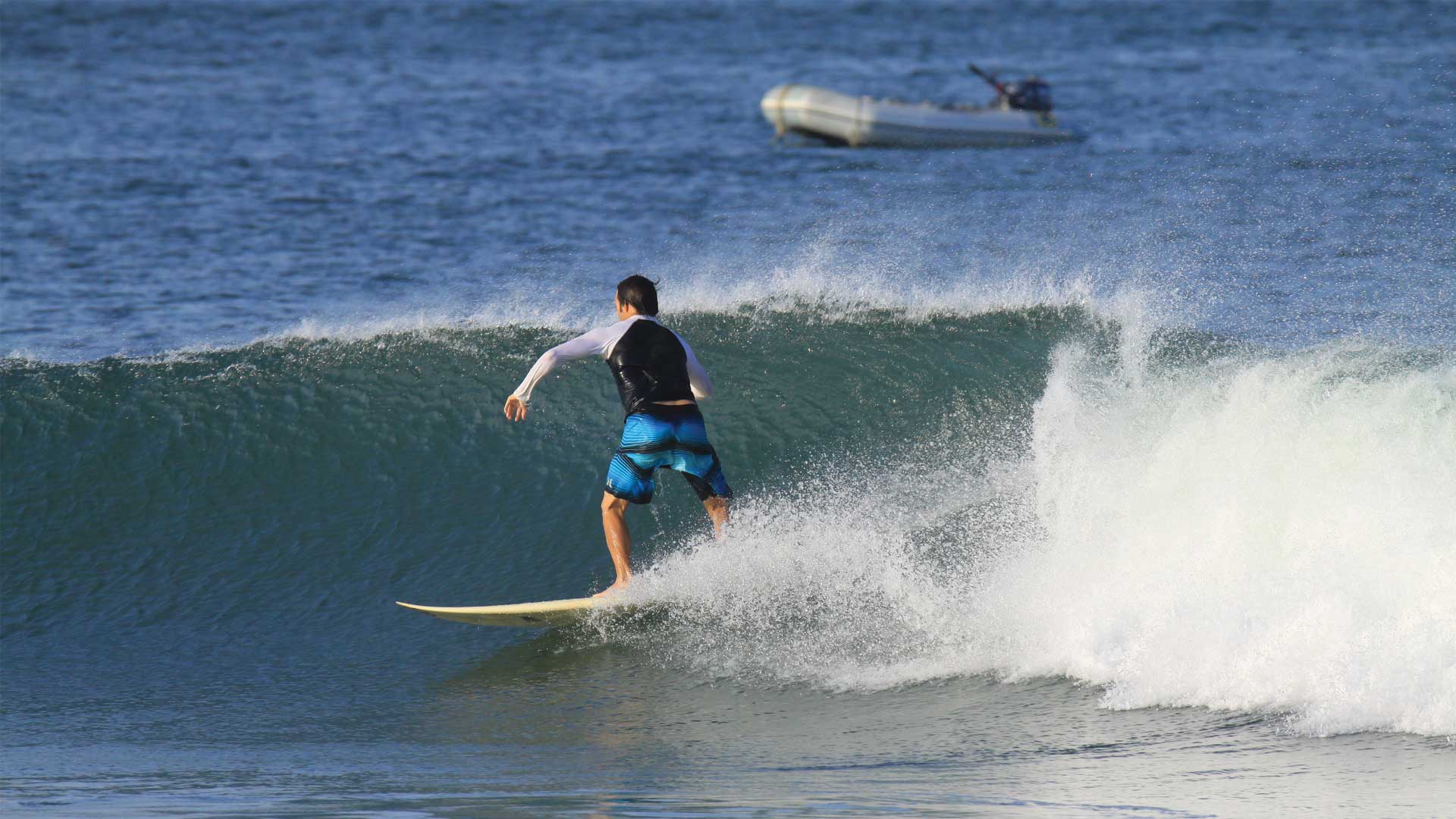 Surfer surfing wave at Playa Grande beach in Guanacaste, Costa Rica