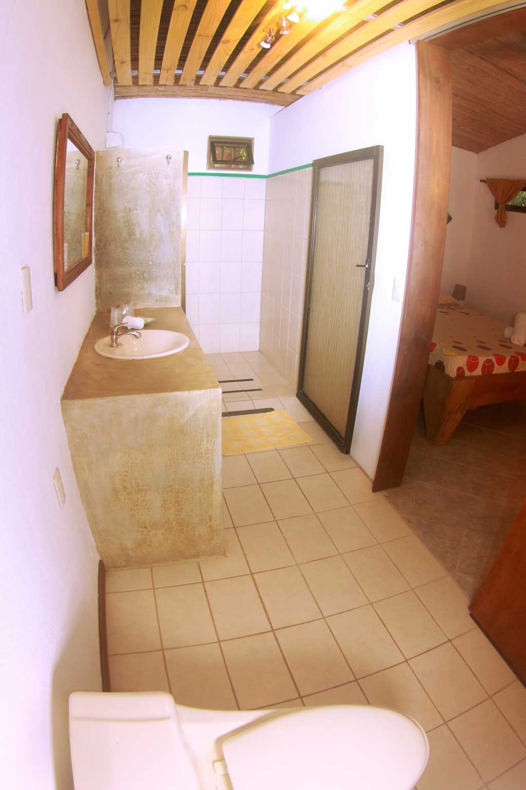En suite bathroom of double room at Indra Inn furnished with a concrete countertop and tiled floors