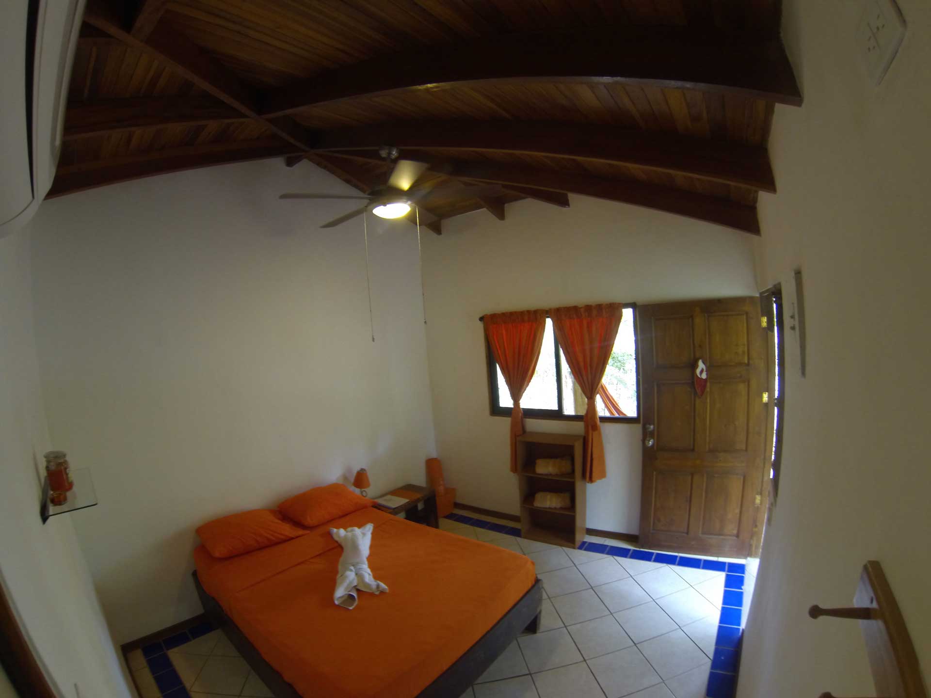 Fisheye view of bed, window, door, and ceiling in double room at Indra Inn