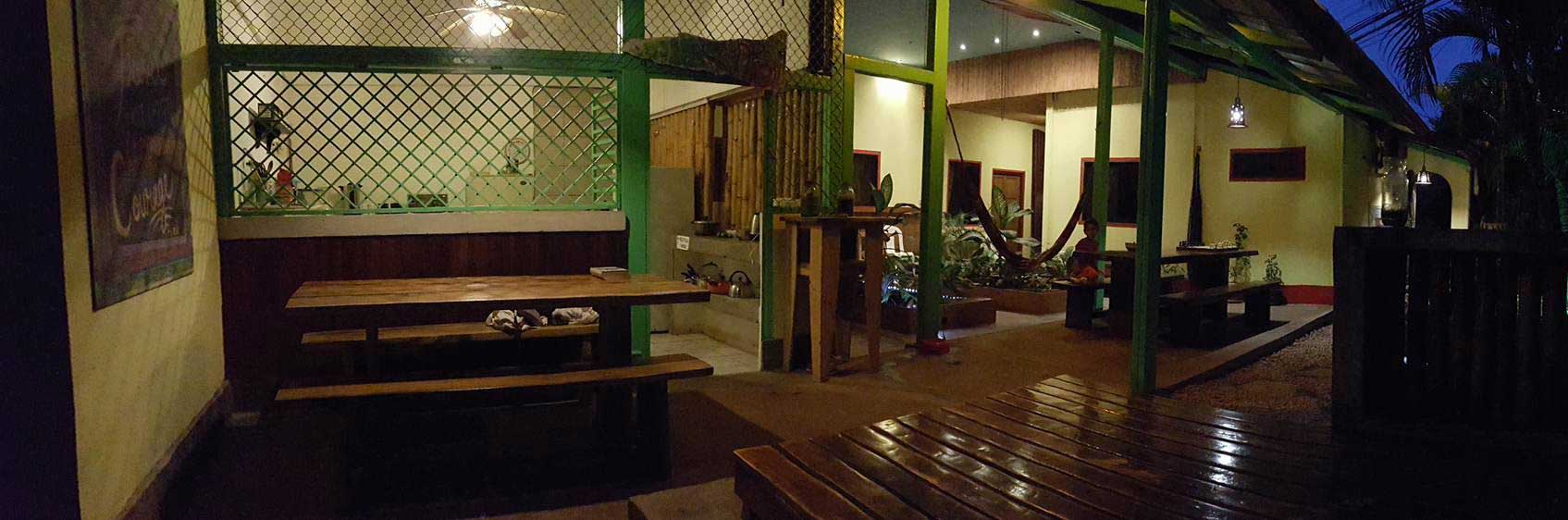 Panorama from the sun terrace of community kitchen and lounge area at night in Indra Inn