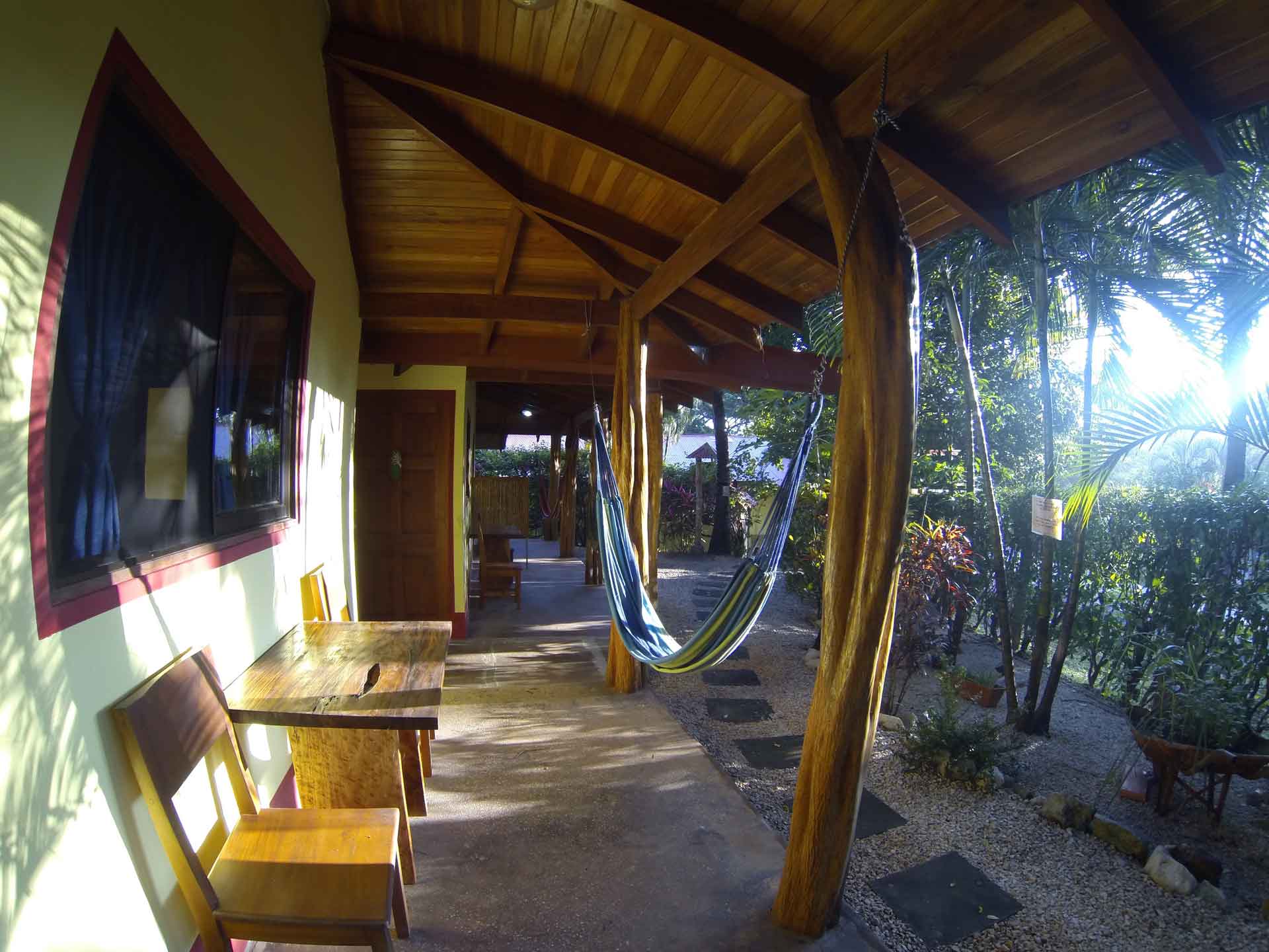 A private patio with chairs, table, and hammock of a double room at Indra Inn