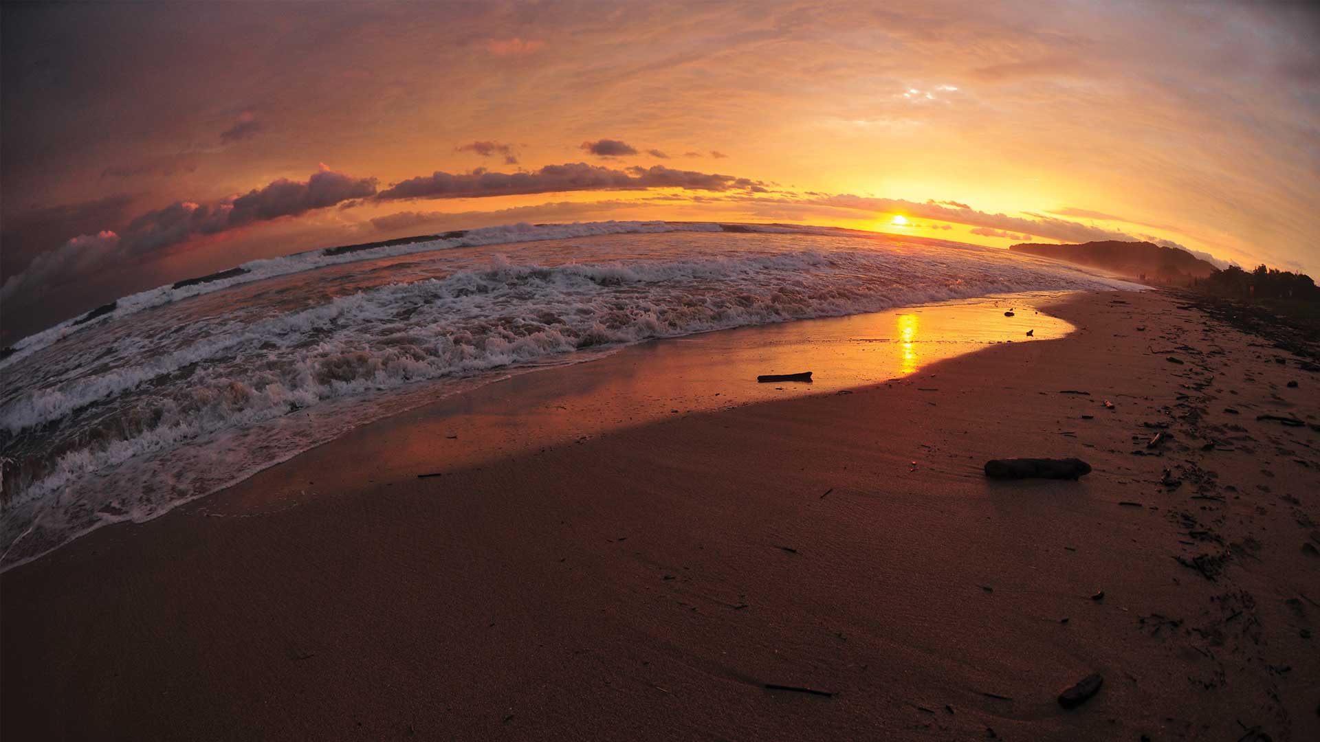 Fisheye sunset lights up the crashing surf in Playa Grande, Costa Rica