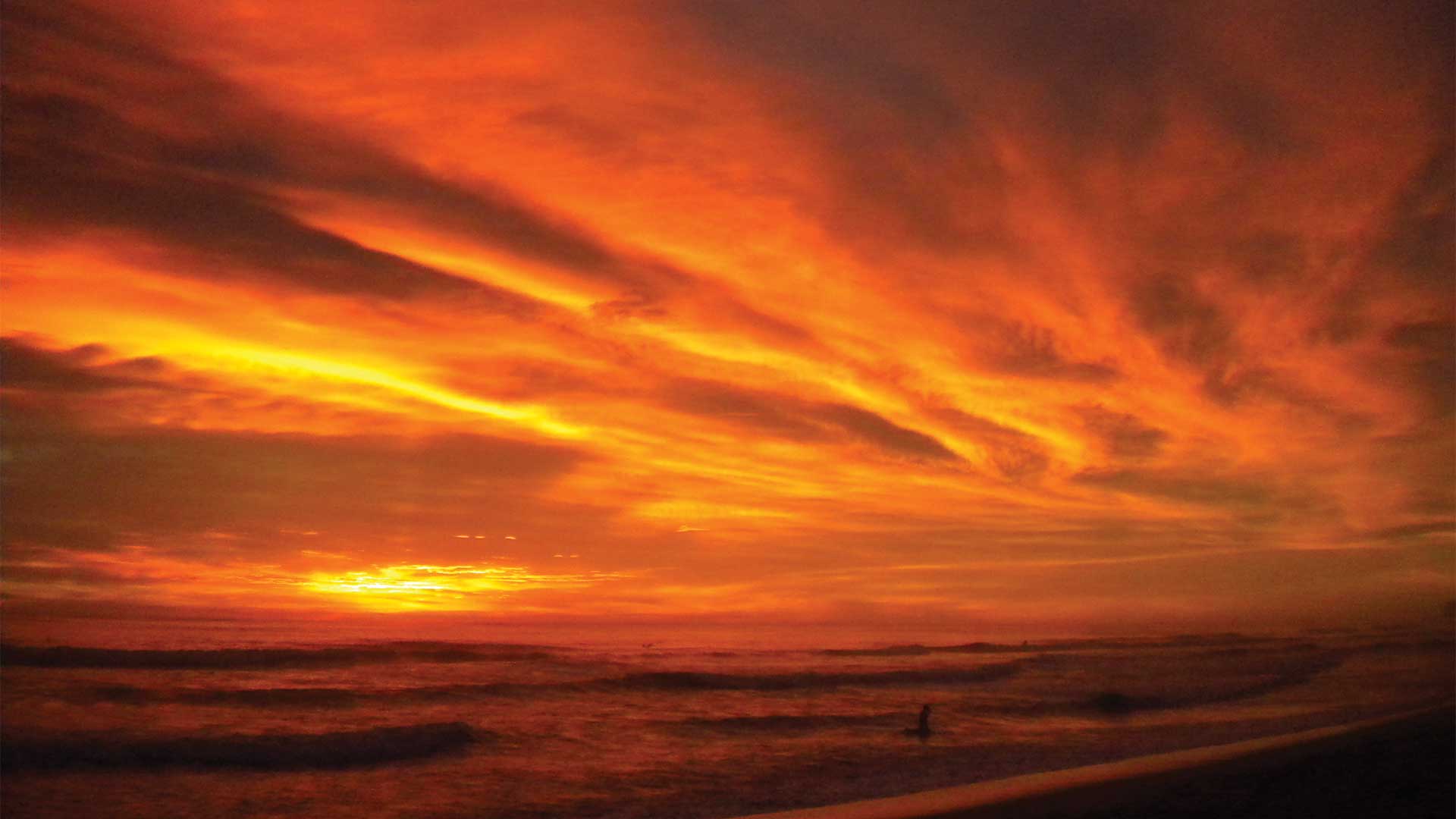 A red sunset lights up the sky at Playa Ventana beach in Guanacaste, Costa Rica