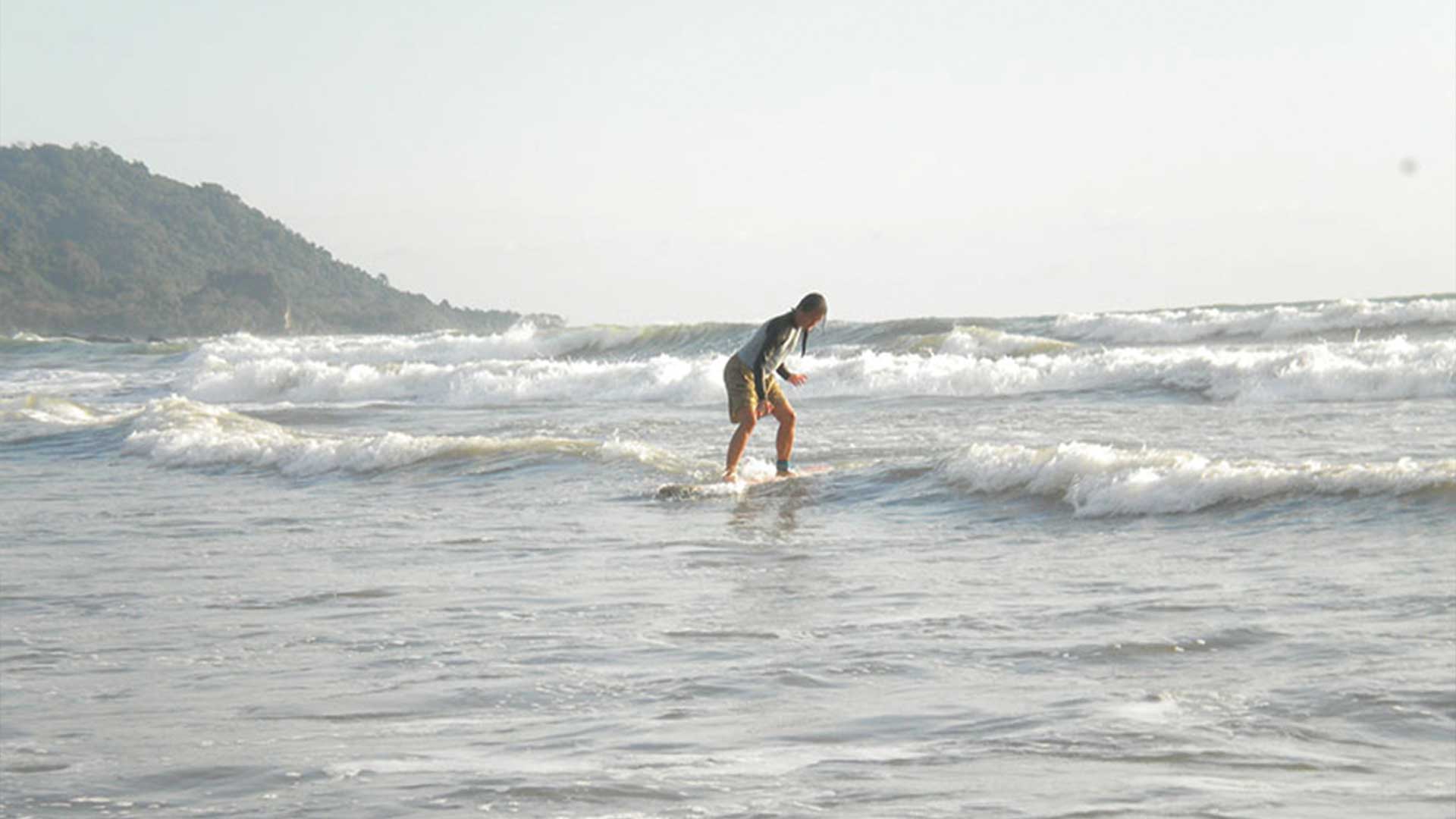 A beginner surfer learning how to surf whitewater waves during lesson at Playa Grande, Costa Rica