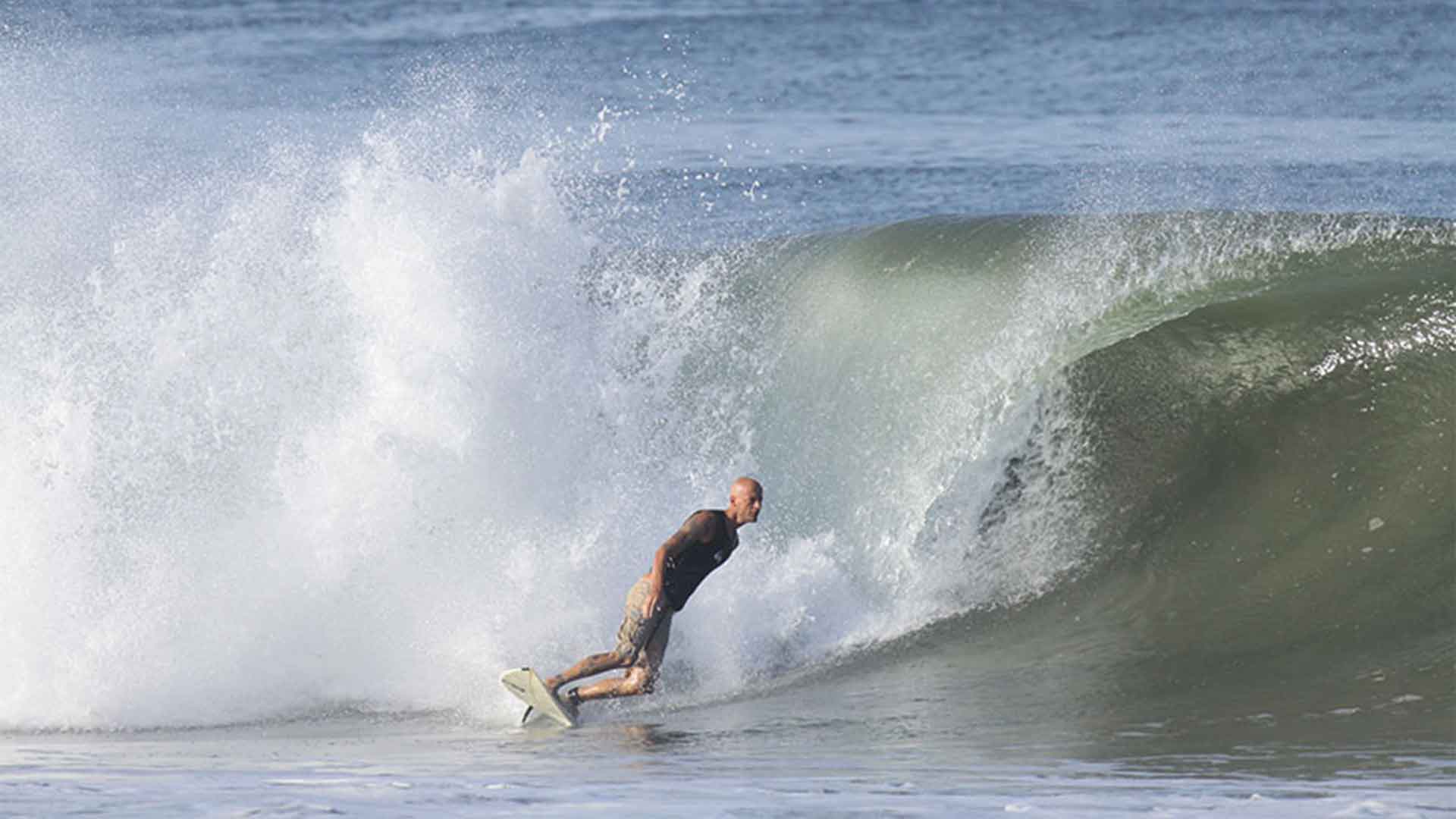 A surfer turning into a cut back on a barrel tube wave in Playa Grande, Costa Rica