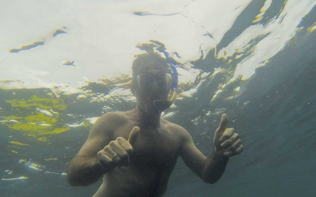 Man snorkeling with two thumbs up in Playa Grande, Costa Rica