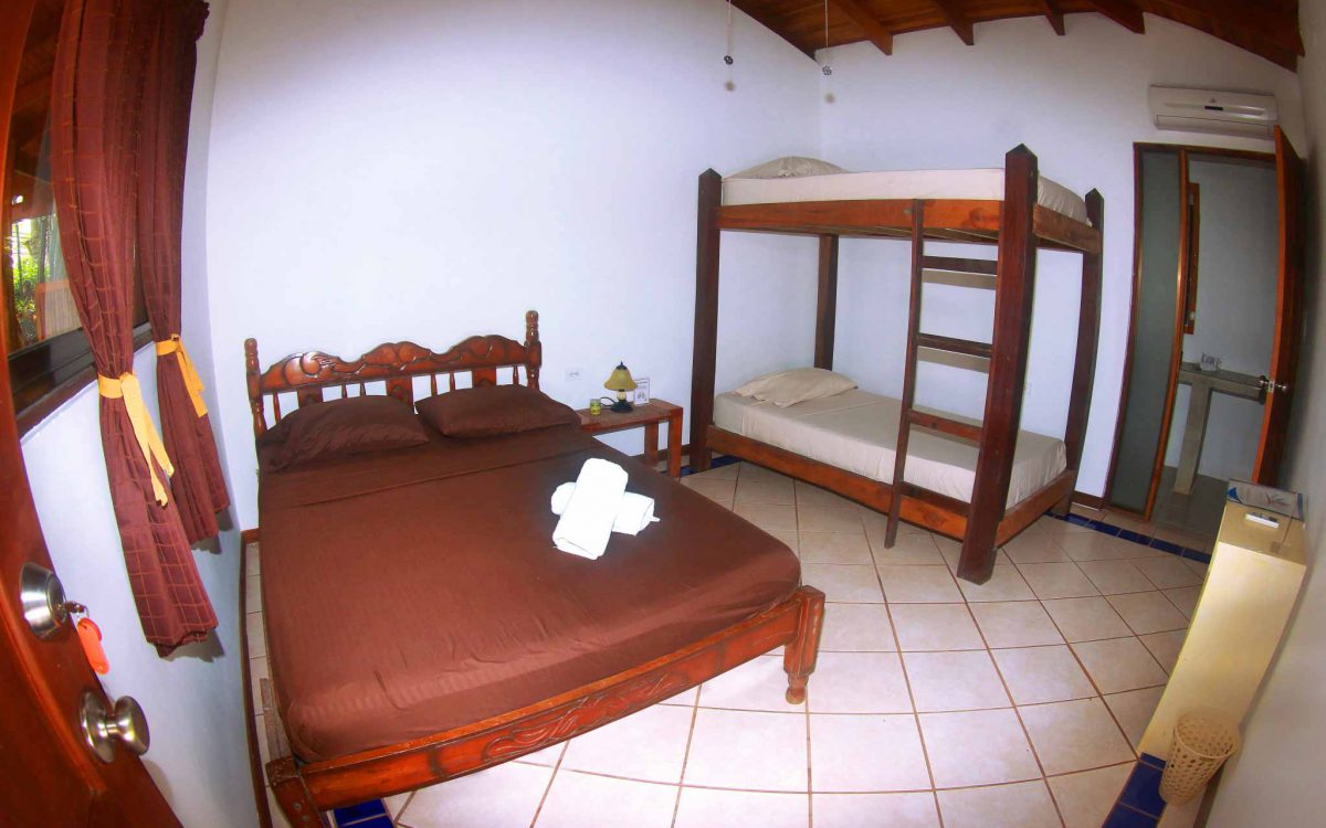 Double bed and bunk beds with en suite bathroom in triple room at Indra Inn